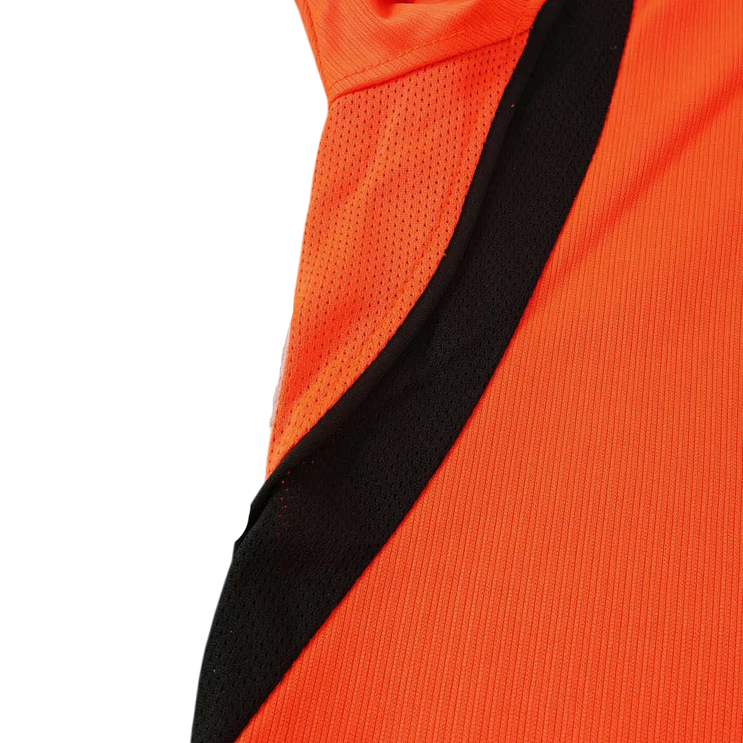 Close-up of an orange sports jersey with black and gray accents on a white background